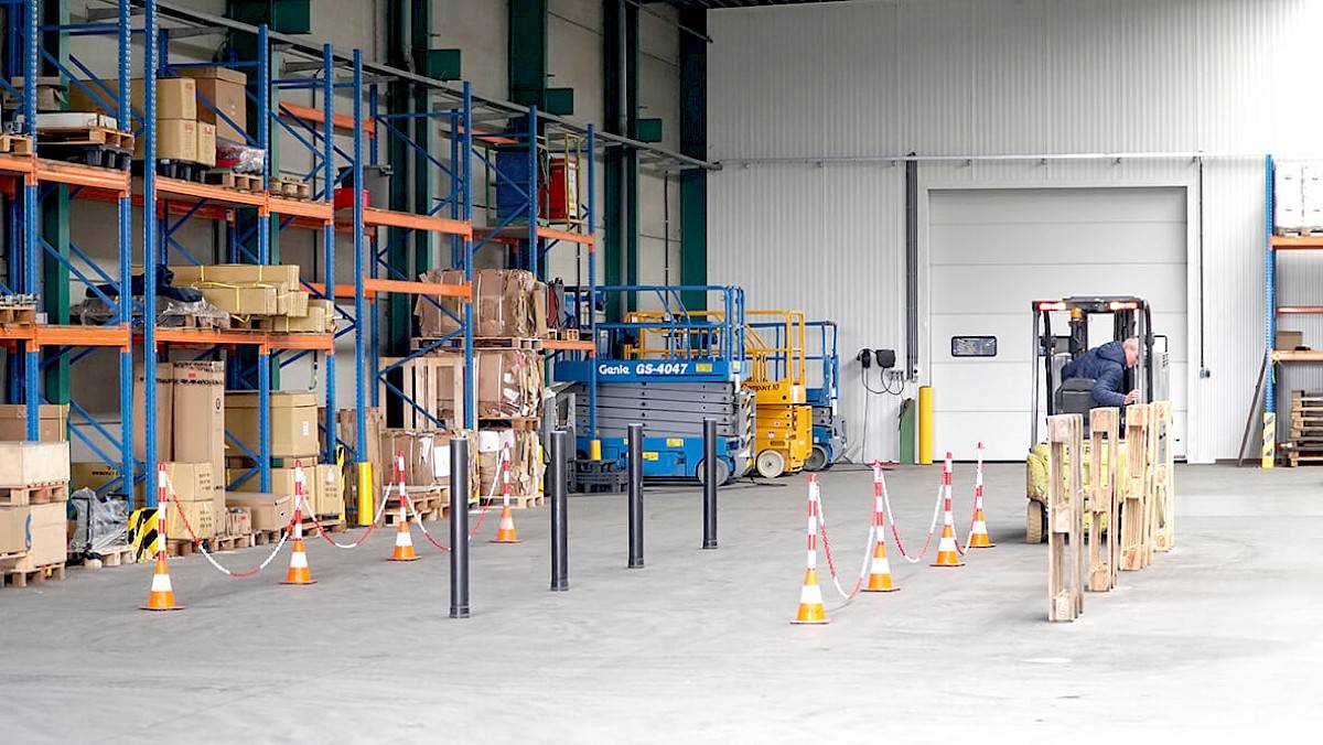 Een man leert met een heftruck rijden in de opleidingscentrum. Leert achteruit parkeren.